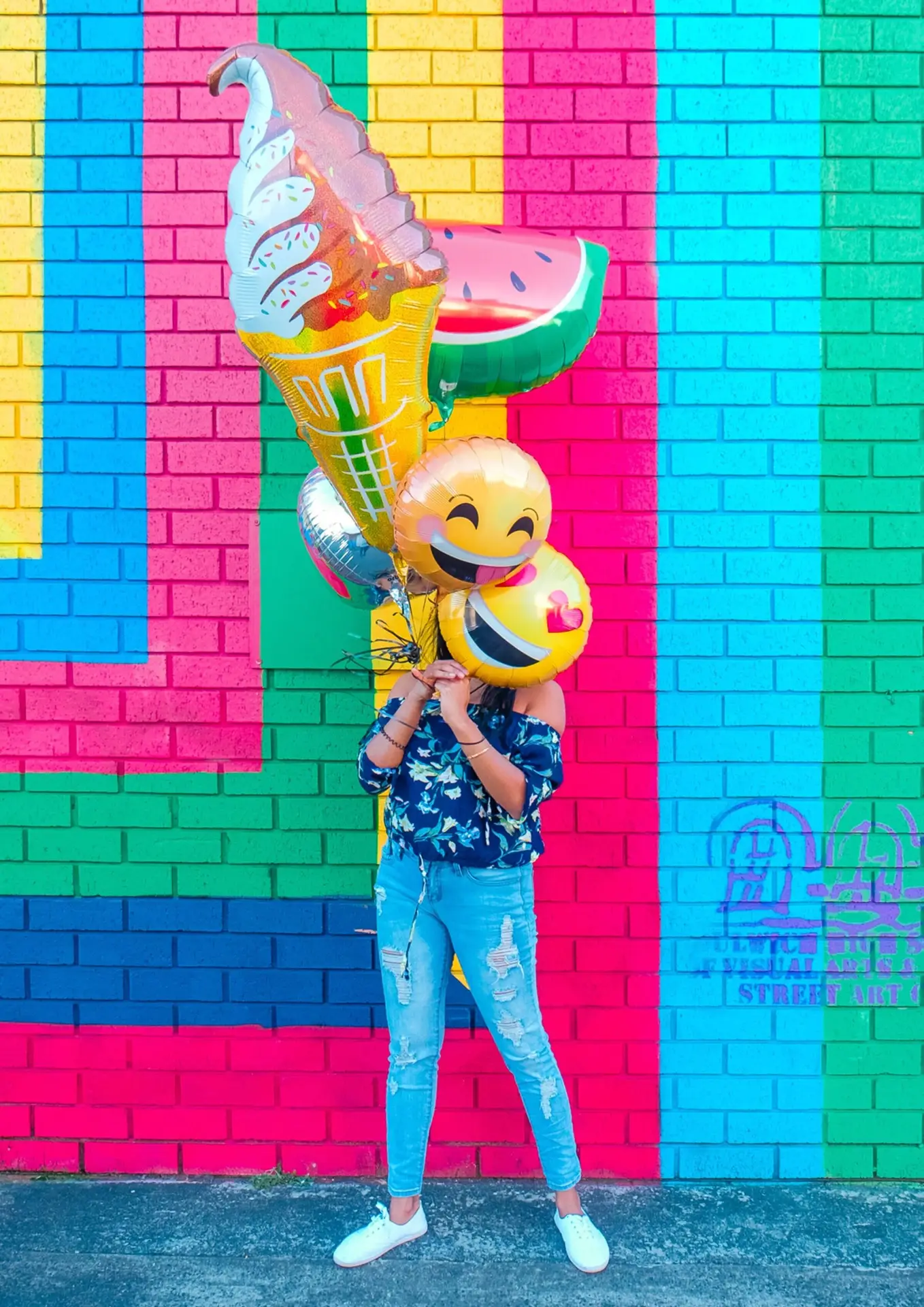 Someone holding colorful balloons. You can't see their face. Lighten Up.